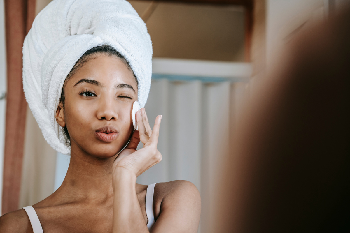 Ethnic woman with folded lips doing skin care procedure